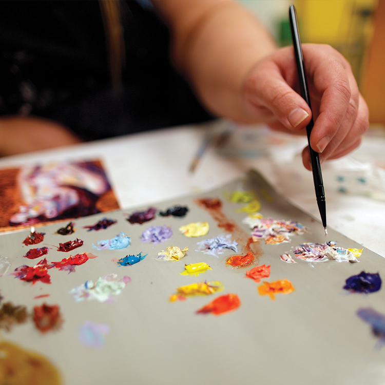 A close up view of a paint palette and brush.